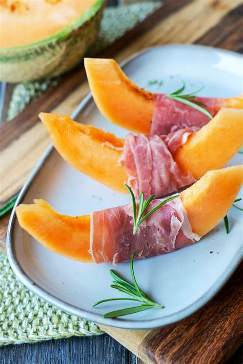 Verschiedene Marmeladengläser mit Melone und Früchten auf Holztisch