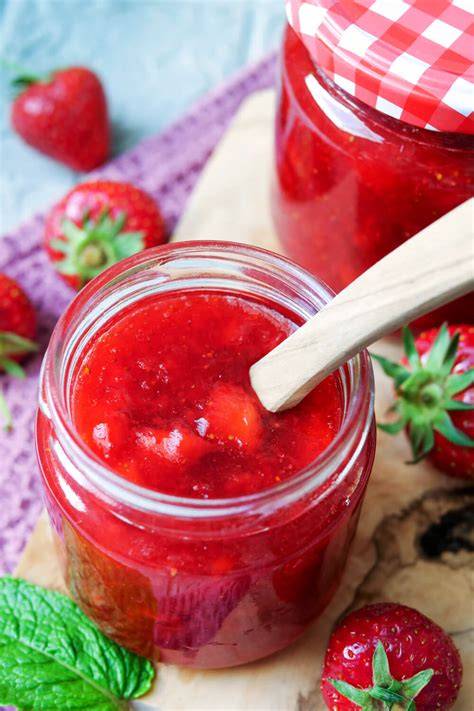 Verschiedene Marmeladengläser mit selbstgemachter Erdbeermarmelade