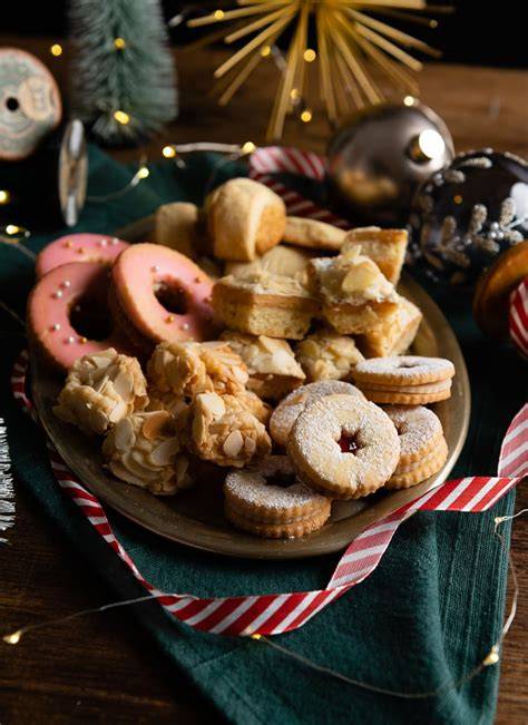 Verschiedene Marzipan-Plätzchen mit Deko auf einem weihnachtlichen Teller