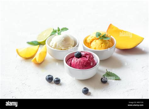 Verschiedene Nicecream-Schälchen mit Beeren, Mango und Schokosplittern