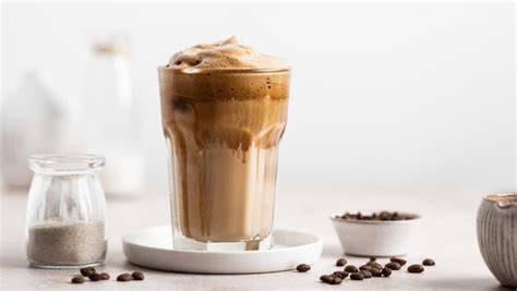 Verschiedene Proteinpulver-Geschmacksrichtungen neben einem Glas Eiskaffee