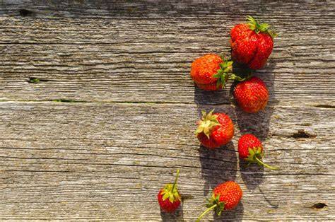 Verschiedene Schnittarten von Erdbeeren auf Holztisch