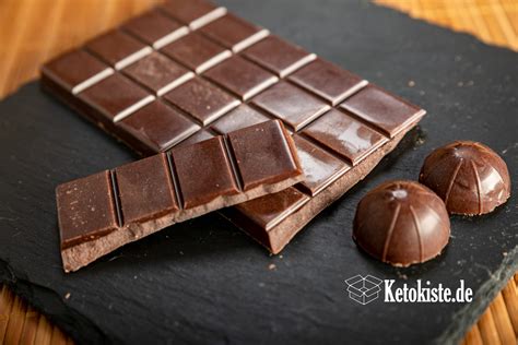 Verschiedene Tafeln Protein-Schokolade und Zutaten (Kakao, Proteinisolat, Erythrit)