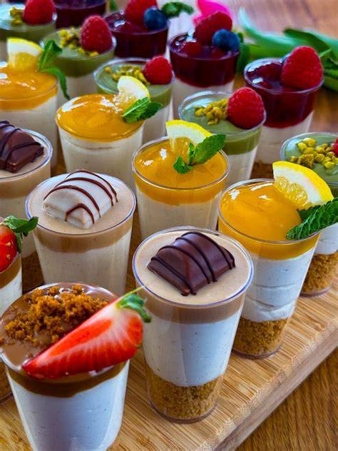 Verschiedene bunte Schichtdesserts im Glas mit dekorativen Toppings