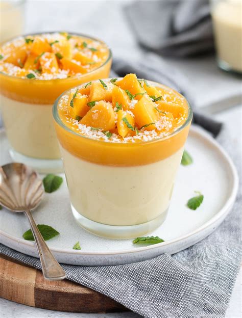 Verschiedene dekorierte Dessertgläser mit Mango Panna Cotta