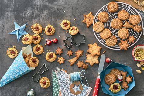 Verschiedene dekorierte Plätzchen in einer gläsernen Keksdose, Geschenkband drumherum