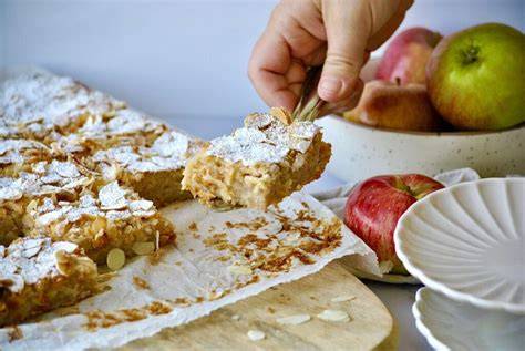 Verzieren des Apfelkuchens mit Mandelblättchen und Zimt