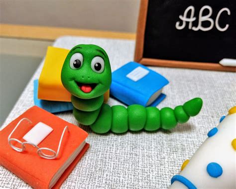Verzierte Buch-Torte mit Kordeln, Lesezeichen und Bücherwurm aus Fondant