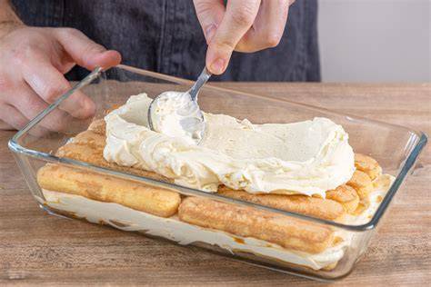 Vorbereitung und Schichten von Tiramisu mit Puderzucker