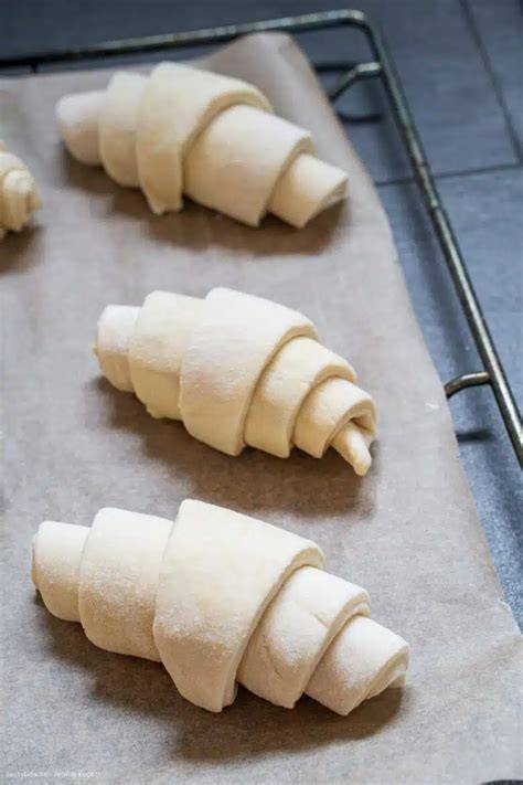 Vorgeformte Croissants auf Backblech vor dem Gehen