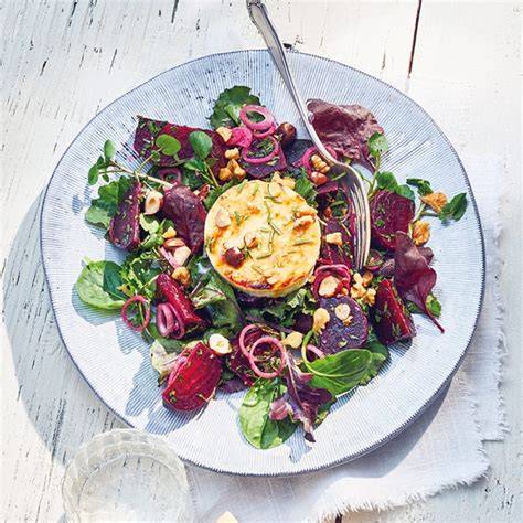 Vorschlag für das Anrichten: Ziegenkäse auf Wildkräutersalat mit Früchten und Nüssen