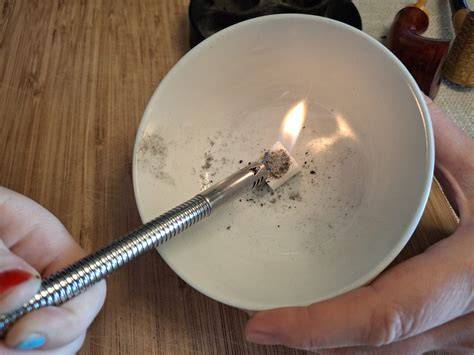 Würfelzucker und Asche auf Löffel über Flamme