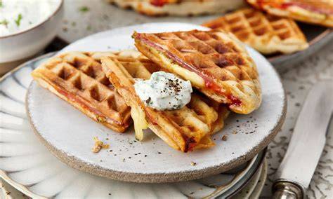 Waffeleisen mit Pizzawaffel beim Herausnehmen