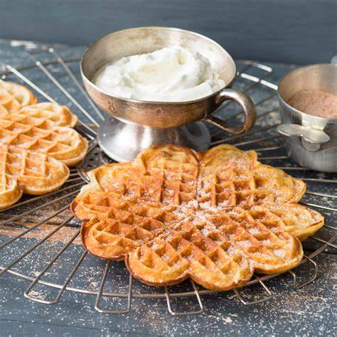 Waffeleisen mit goldbraunen Waffeln und Crème fraîche