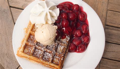 Waffeln mit Sahne, heißen Kirschen und Vanilleeis