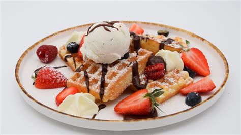 Waffeln mit Toppings wie Beeren, Obstmus oder Schokosauce