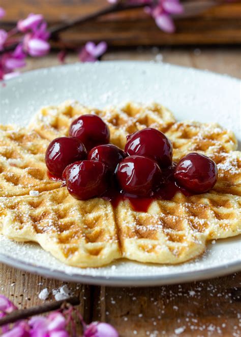 Waffeln mit heißen Kirschen auf einem Teller