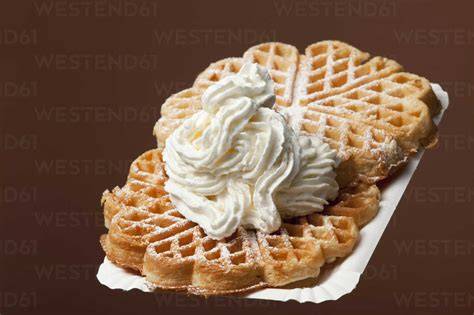 Waffeln mit saurer Sahne, angerichtet mit Puderzucker und Beeren