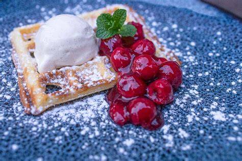 Waffeln mit verschiedenen Toppings: Kirschen, Sahne, Eis