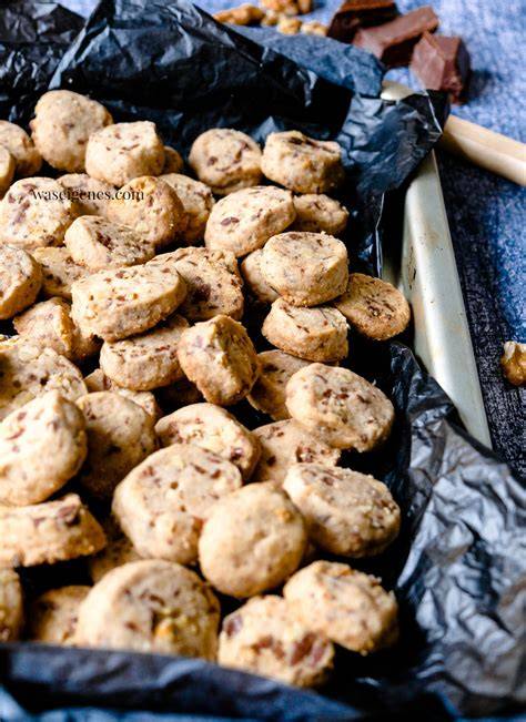 Walnuss Kekse auf Backblech, Zutaten im Hintergrund