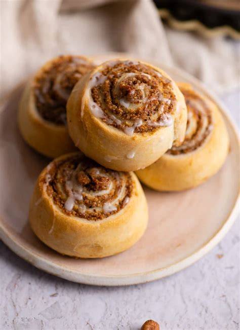 Warme Nussschnecken mit Zuckerguss auf einem Brett serviert