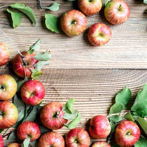 Weißdornbeeren und Äpfel auf Holztisch