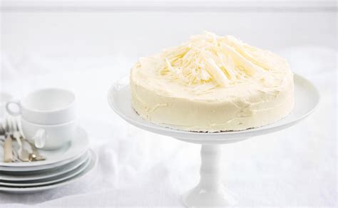 Weiße Sachertorte auf Teller, Anschnitt zeigt weiße Glasur