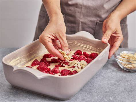 Weiße Schokoladenschicht auf Himbeeren verteilen