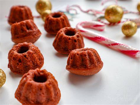 Weihnachtlich dekorierte Lebkuchen Mini Gugelhupfe auf einem rustikalen Holztisch