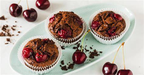 Weihnachtliche Muffins und Kuchenstückchen mit Kirschen und Schokoglasur