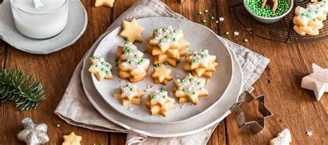 Weihnachtliche Plätzchen-Auswahl auf einem Teller mit Streuseln, Zuckerguss und Ausstechformen