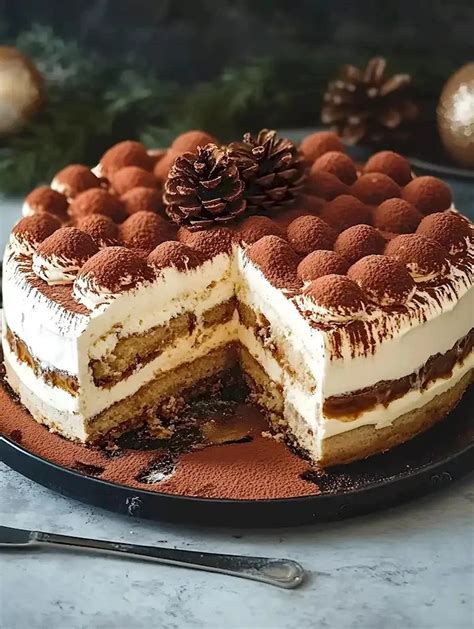 Weihnachtliches Tiramisu auf einem Tisch neben Tasse Tee und Kamin
