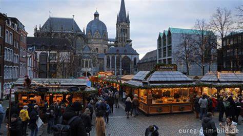 Weihnachtsmarkt in Aachen mit Printenständen und Dom im Hintergrund