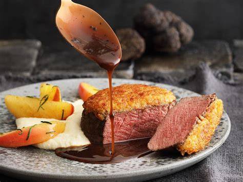 Weinglas neben einem Filetsteak mit Trüffel