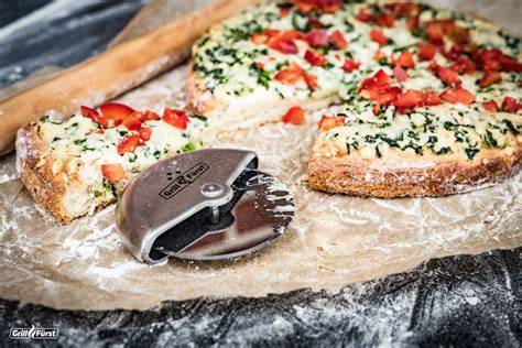 Werkzeug-Flatlay: Pizzaschneider, Lineal, Mini-Teigroller, Backpapier