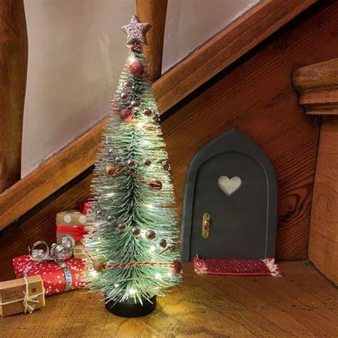 Wichteltür im Advent an einer Holztreppe mit Mini-Deko und Fußmatte