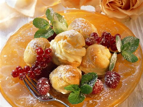 Windbeutel mit Schokoladenglasur und Beeren auf Dessertgläsern
