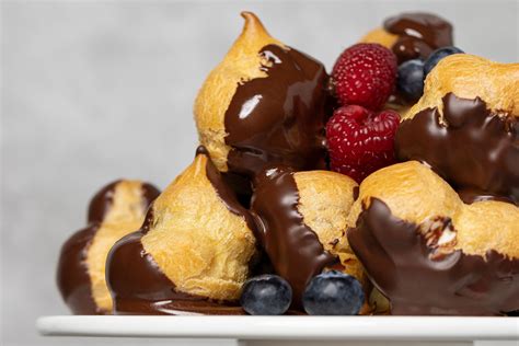 Windbeutel und Profiteroles mit Sahne und Früchten gefüllt