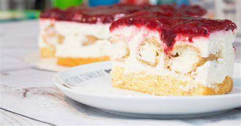 Windbeuteltorte mit roter Grütze und frischen Himbeeren als Dekoration