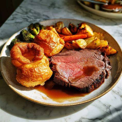 Yorkshire Pudding mit Bratensoße und Roastbeef als klassisches Sunday Roast