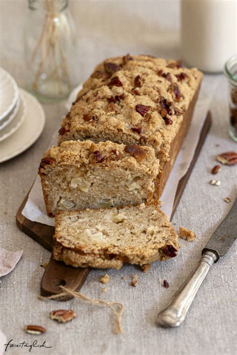 Zimtiger Apfelkastenkuchen mit Pekannüssen auf rustikalem Holztisch mit Zimtzweigen