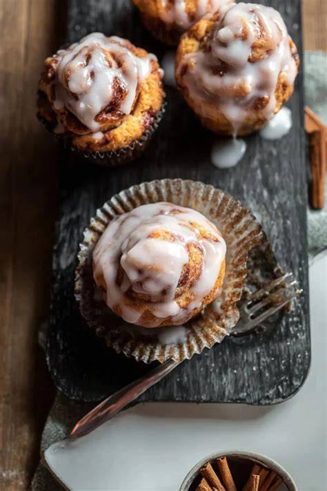 Zimtschnecken-Muffins auf einem Teller, mit Glasur und Streuseln