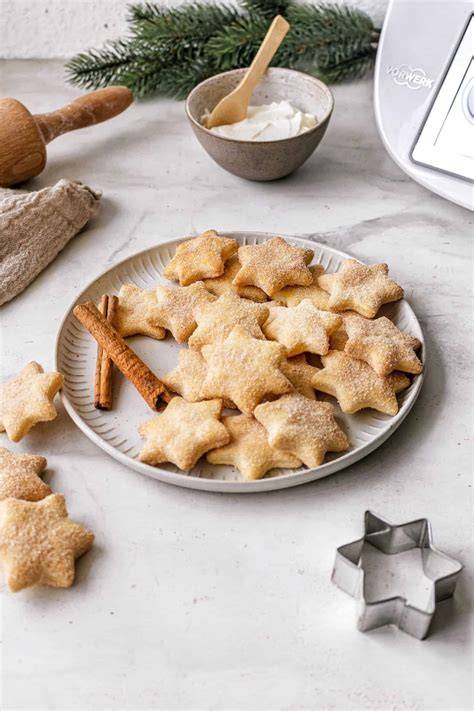 Zimtstangen und fertige Plätzchen auf Teller