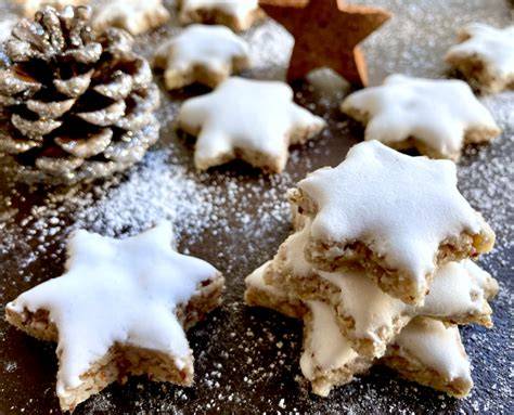 Zimtsterne mit Zitronen-Zuckerguss serviert auf weihnachtlicher Platte