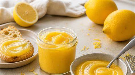 Zitronen, geriebene Schale und Lemon Curd im Topf