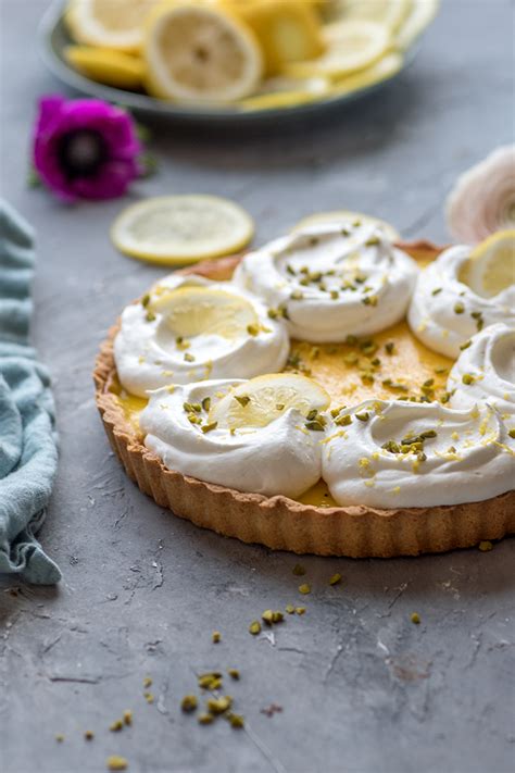 Zitronen Tarte auf Kuchenteller, garniert mit Schlagsahne