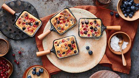 Zitronen-Wölkchenkuchen mit Puderzucker und Beeren