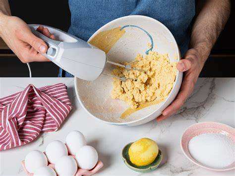 Zitronenabrieb, Vanilleschote und Schüssel mit Quarkmasse; Pfeile zu Puddingpulver und Sahne als Infografik