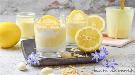 Zitronencreme im Glas angerichtet mit Zitronenscheiben und Minze
