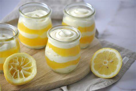 Zitronencreme im Glas mit frischen Zitronen und Kräutern dekoriert